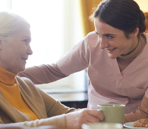 Caregiver looking older woman in the eye and reassuring her